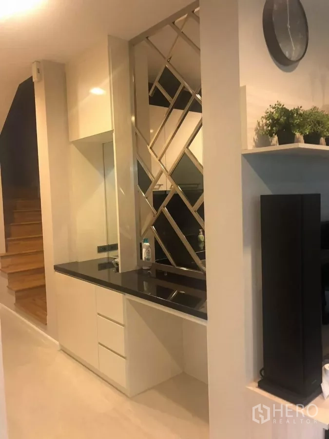 Detached House for rent in Bang Kapi, Bangkok - Hallway with mirrored partition, built-in counter and wooden staircase.