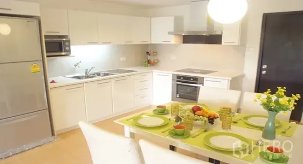 อพาร์ทเมนท์ ให้เช่าในKhlong Toei, Bangkok - ครัวโทนขาวพร้อมเตาอบ ไมโครเวฟ ตู้เย็นขนาดใหญ่ และโต๊ะอาหาร 4 ที่นั่ง ใต้โคมไฟ