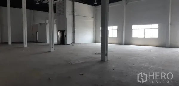 Factory for rent in Lat Krabang, Bangkok - Spacious warehouse hall with high ceilings, tall windows, and multiple support columns.