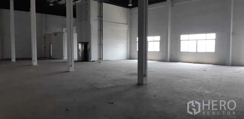 Factory for rent in Lat Krabang, Bangkok - Spacious warehouse hall with high ceilings, tall windows, and multiple support columns.