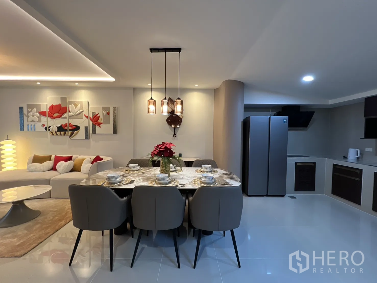 Townhouse for rent in Bang Phli, Samut Prakan - Open-plan layout showing the sofa, dining table and pendant lights next to the kitchen.