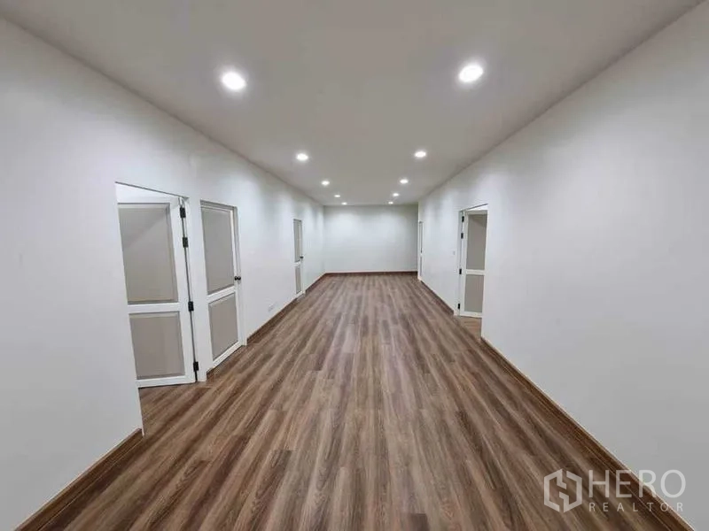 อาคารพาณิชย์ ให้เช่าในBang Rak, Bangkok - โถงทำงานยาว พื้นไม้ มีประตูเข้าห้องย่อยทั้งสองด้านและไฟเพดาน