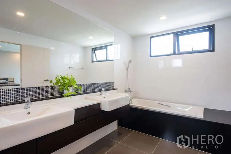 独立式住宅 出租或出售在Kanchanaburi - 现代浴室，双台盆、浴缸与大镜面。