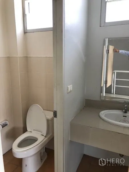 工厂 出租在Pathum Thani - 整洁的卫生间，配坐便器、洗手盆与镜子