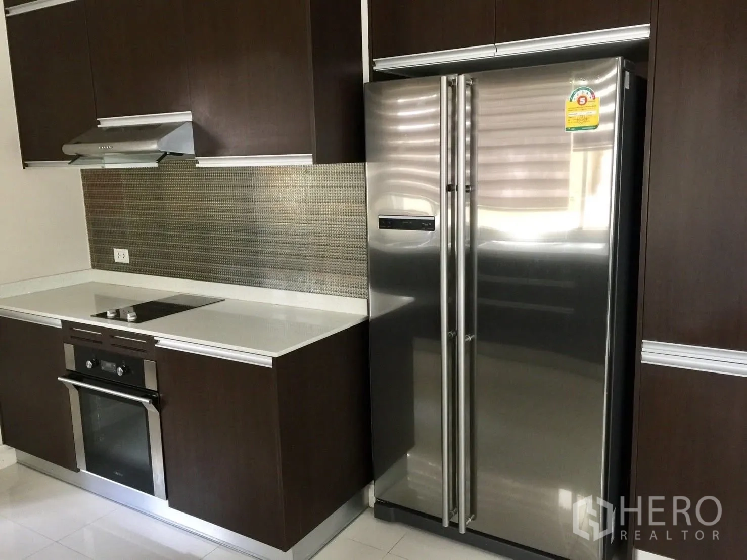 独立式住宅 出租在Prawet, Bangkok - 西式厨房，内嵌烤箱、灶台、油烟机和对开门冰箱。