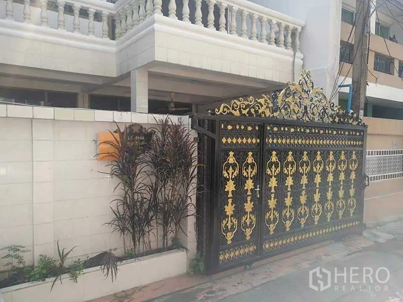 ทาวน์เฮาส์ ให้เช่า - ด้านนอกทาวน์เฮ้าส์มีกำแพงสีขาวและประตูรั้วเหล็กลายทอง