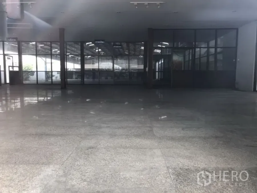 零售空间 出租在Huai Khwang, Bangkok - 宽敞展示厅内景，抛光地面、挑高天花与玻璃分隔办公室。