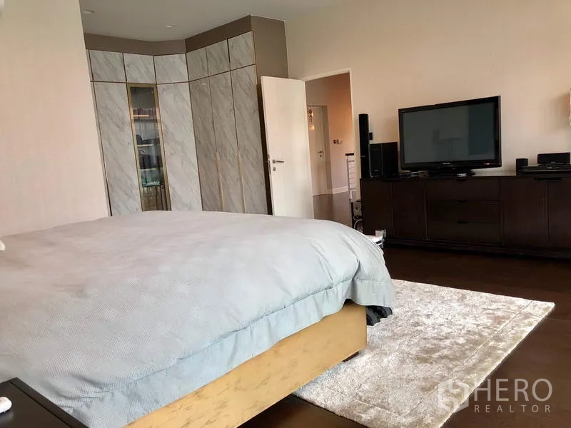 Detached House for rent or sale in Bang Kapi, Bangkok - Master bedroom angle showing built-in wardrobe and TV cabinet opposite the bed.