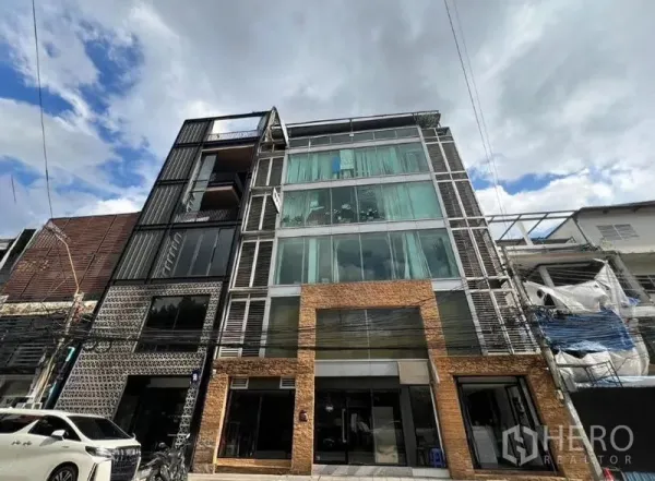 零售空间 出租在Bang Rak, Bangkok - 多层建筑正立面，大片玻璃与砖面入口。