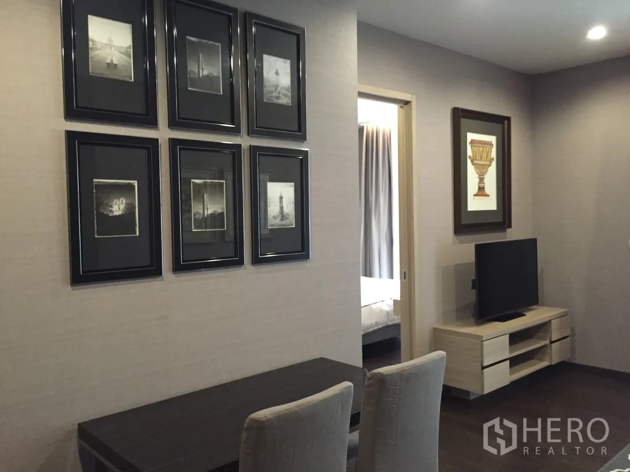 公寓 出租在Watthana, Bangkok - 明亮客厅，电视柜与相框墙，通往卧室的门，曼谷公寓。