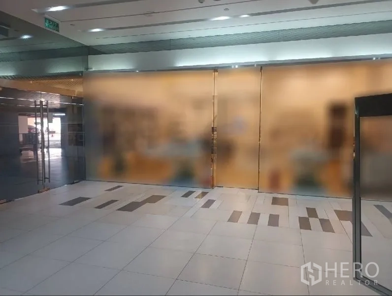 พื้นที่ขายปลีก ให้เช่าในKhlong Toei, Bangkok - หน้าร้านกระจกเต็มบานพร้อมประตูคู่ เปิดสู่โถงทางเดินศูนย์การค้าปูกระเบื้องสว่างในกรุงเทพฯ