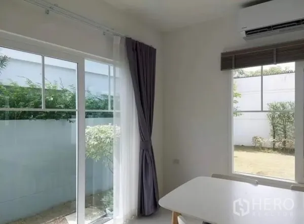 Detached House for rent in Bang Bo, Samut Prakan - Dining nook with corner windows, long curtains and views to the lawn garden.