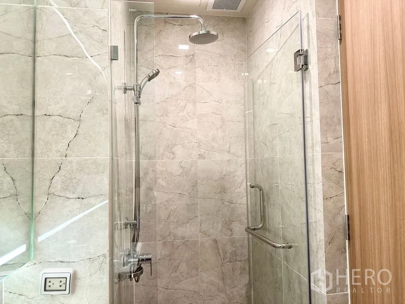公寓 出租在Watthana, Bangkok - 浴室配玻璃隔断与顶喷雨淋花洒，石纹墙面。