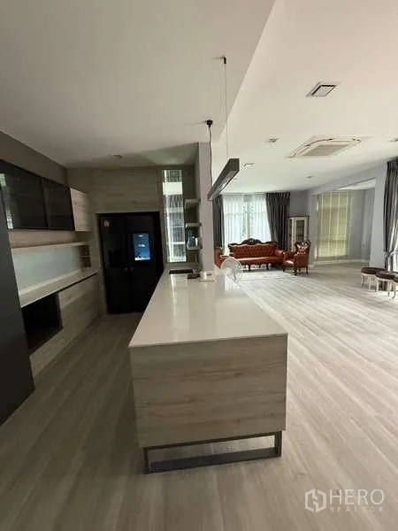 Detached House for rent or sale in Bang Bua Thong, Nonthaburi - Open-plan western kitchen with long island, pendant lights, and outlook to living area.