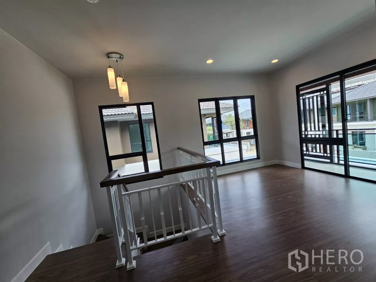 บ้าน ขายในLam Luk Ka, Pathum Thani - พื้นที่นั่งเล่นชั้นสองพร้อมโคมไฟแขวนและหน้าต่างบานใหญ่