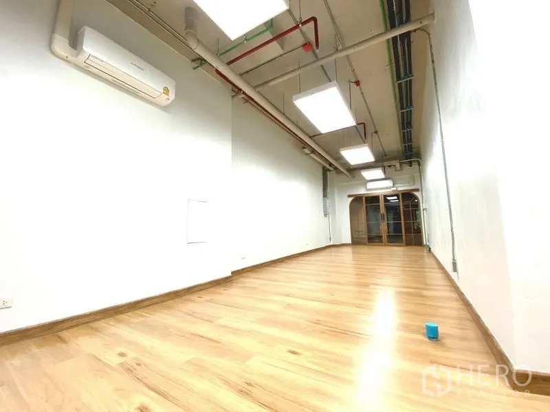 Office Space for rent in Khlong Toei, Bangkok - Light‑filled office interior with split air conditioner, white walls and LED ceiling lights.