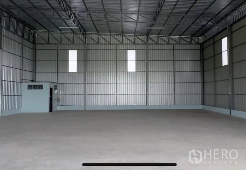 คลังสินค้า ให้เช่าในLam Luk Ka, Pathum Thani - คลังสินค้าด้านในเพดานสูง ผนังเมทัลชีท และห้องน้ำก่อสร้างในมุมอาคาร