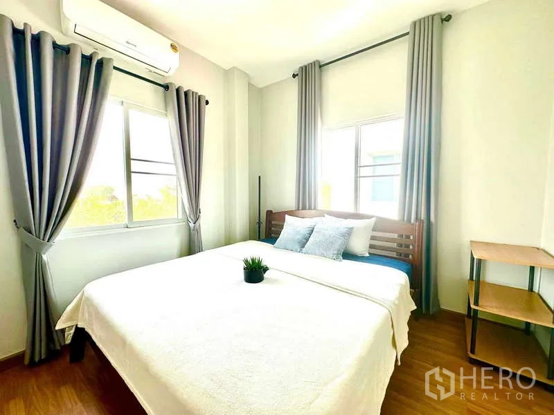 บ้าน ให้เช่าในLat Krabang, Bangkok - ห้องนอนรับแสงธรรมชาติ เตียงคู่ เครื่องปรับอากาศ ผ้าม่านสีเทา และพื้นไม้