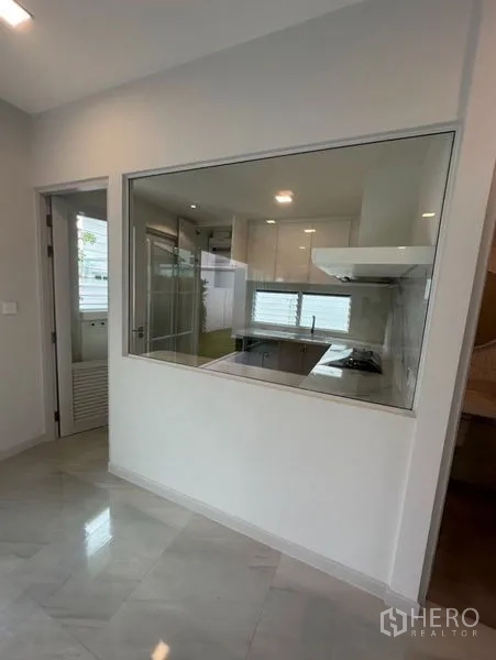 Detached House for rent - Enclosed Thai kitchen viewed through an interior glass partition with cooktop and ventilation.