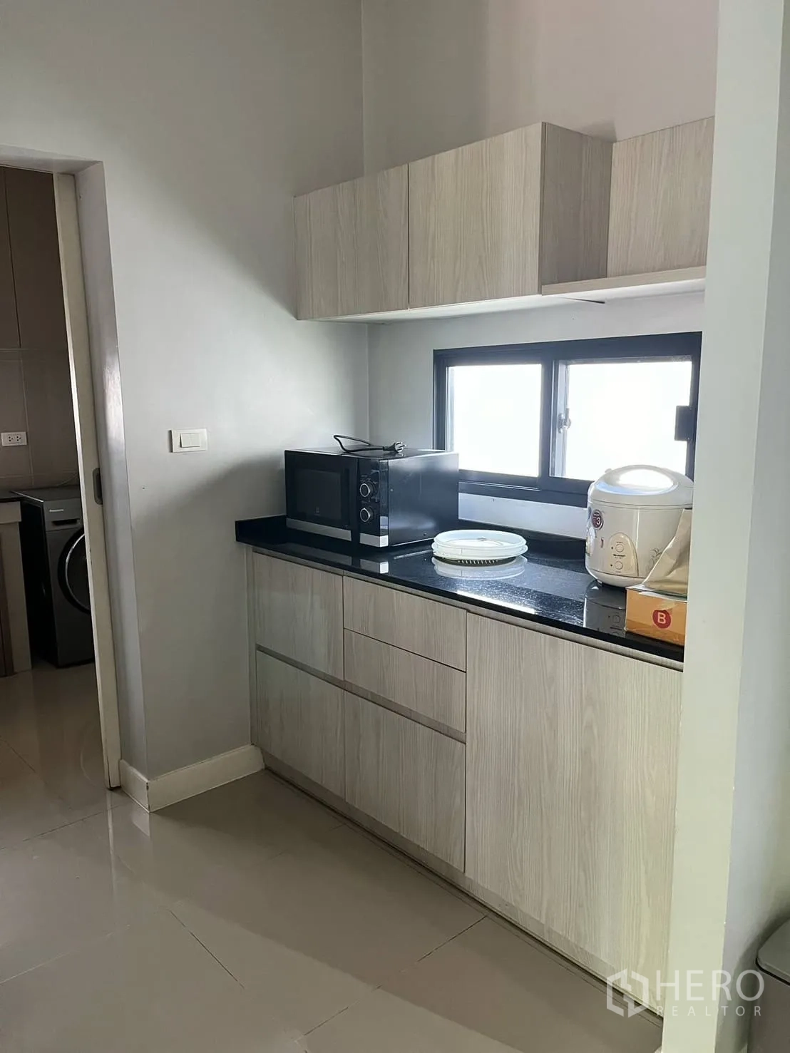 บ้าน ให้เช่าหรือขายในLam Luk Ka, Pathum Thani - แพนทรี่ตู้ไม้สีอ่อน ท็อปสีดำ และเครื่องใช้ไฟฟ้า