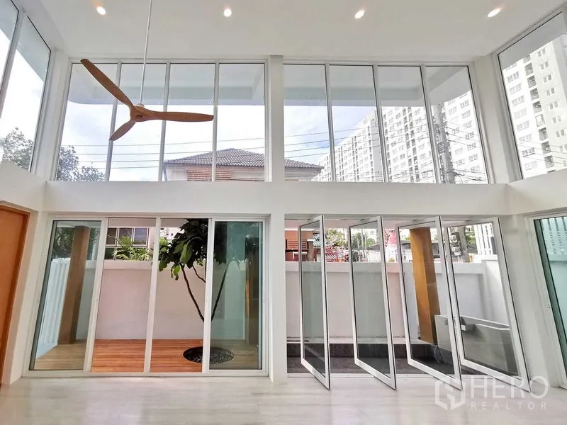 Home Office for sale in Suan Luang, Bangkok - Double-height living space with full-height glazing and an indoor courtyard tree.