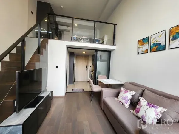 公寓 出租 - 邦拉克公寓的Loft客厅，带夹层卧室、沙发、电视、用餐区与楼梯。