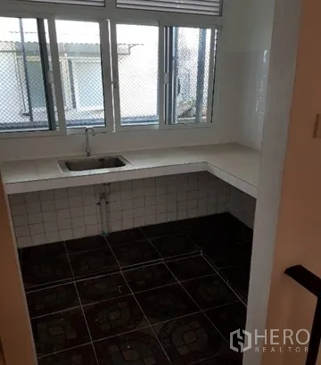 店屋 出租在Watthana, Bangkok - 简易厨房，单槽水槽、瓷砖台面与带防护网的窗户。