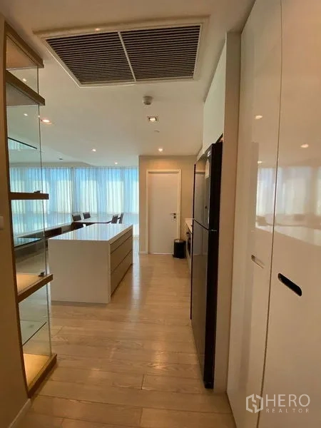 คอนโด ขายในWatthana, Bangkok - มุมมองโถงทางเดินสู่ครัวและพื้นที่รับประทานอาหาร พื้นไม้และผ้าม่านโปร่งสูง