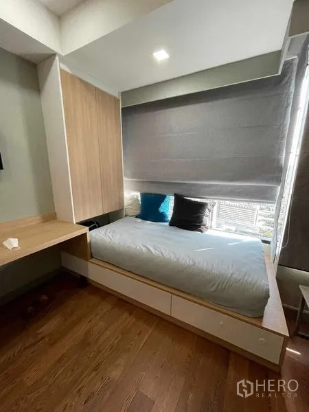 คอนโด ให้เช่าหรือขายในBang Rak, Bangkok - ห้องนอนกะทัดรัด เตียงยกพื้นมีลิ้นชัก ม่านกรองแสง และหน้าต่างวิวเมือง