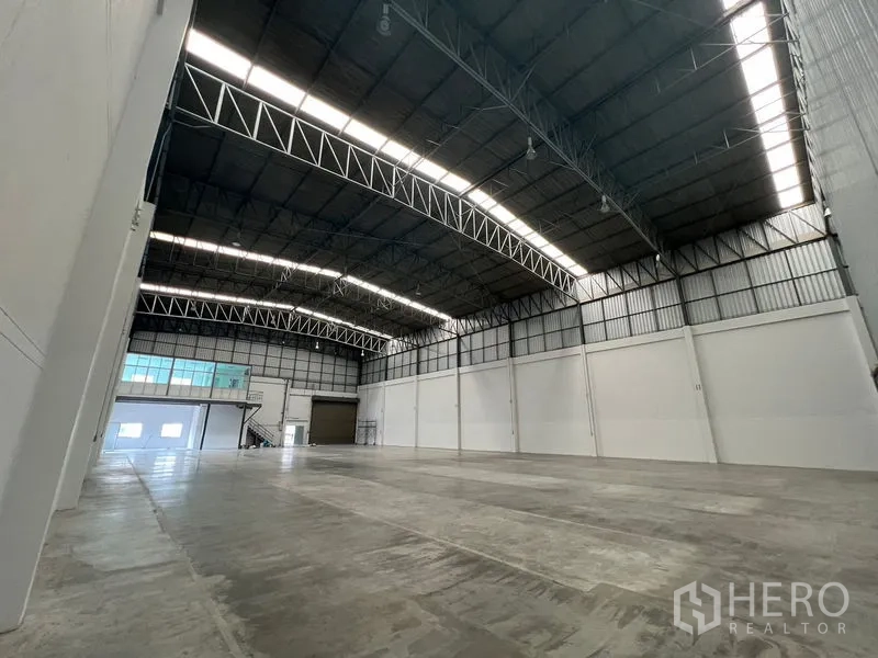 Warehouse for rent in Lat Krabang, Bangkok - High-bay warehouse interior with steel trusses and natural light panels along the roof.
