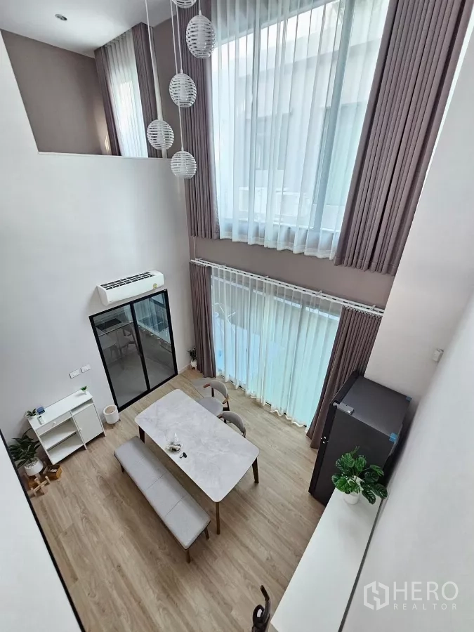 ทาวน์เฮาส์ ให้เช่าในSaphan Sung, Bangkok - พื้นที่รับประทานอาหารเพดานสูงสองชั้น พร้อมผ้าม่านสูงและโคมไฟแขวน