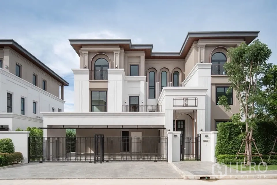 บ้านเดี่ยว for rent or sale in Saphan Sung, Bangkok - ด้านหน้าบ้านเดี่ยวสามชั้นทรงโอ่อ่าพร้อมที่จอดรถในร่มภายในรั้ว
