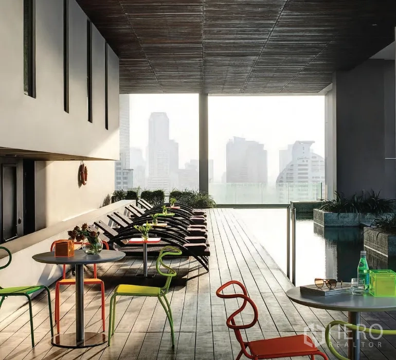 อพาร์ทเมนท์ ให้เช่าในKhlong San, Bangkok - ดาดฟ้าสระว่ายน้ำแบบมีหลังคา พร้อมเตียงอาบแดดและโต๊ะนั่ง ชมวิวสกายไลน์กรุงเทพฯ