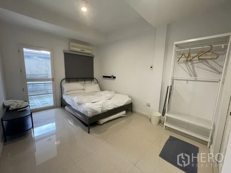 สำนักงานที่บ้าน ให้เช่าหรือขายในWatthana, Bangkok - ห้องนอนติดแอร์ เตียงคู่ ประตูกระจกออกระเบียง และราวแขวนเสื้อผ้า