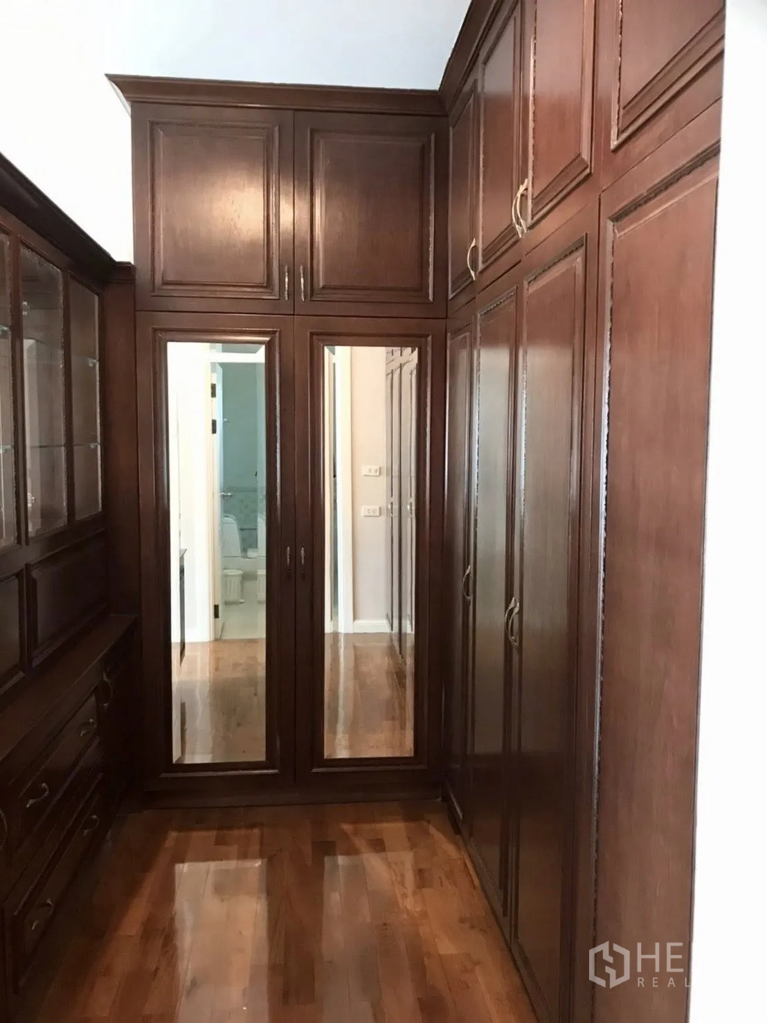 Detached House for rent in Mueang Samut Prakan, Samut Prakan - Walk-in closet lined with tall wooden wardrobes and mirrored doors.