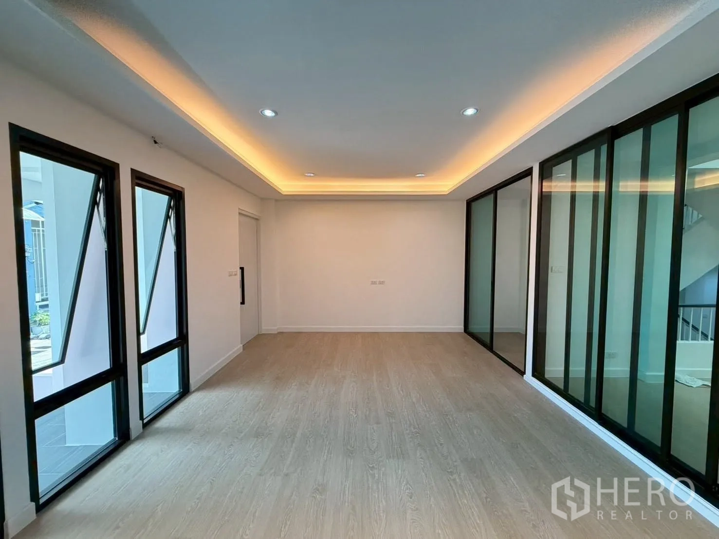 联排别墅 for sale in Phra Khanong, Bangkok - 以整面落地移门分隔的房间与转角窗。