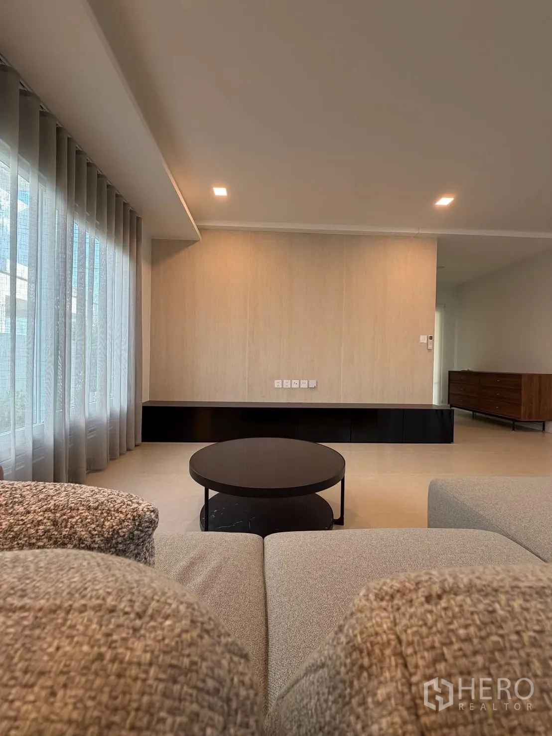 บ้าน ให้เช่าในBang Na, Bangkok - ผนังทีวีและมุมนั่งเล่น มองจากโซฟา พร้อมชั้นวางเตี้ยบิวท์อิน