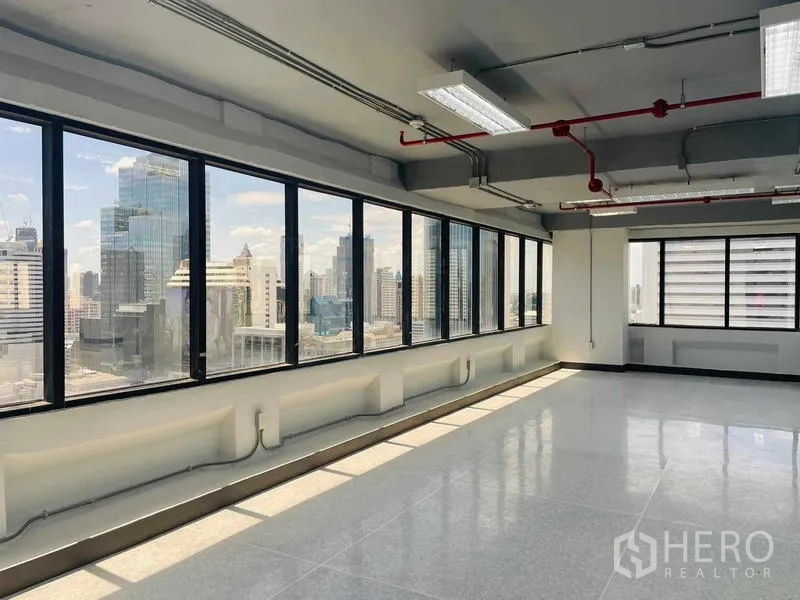 Office Space for rent in Bang Rak, Bangkok - Corner office area with a long wall of windows offering wide city skyline views and natural light.