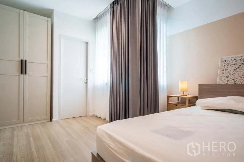 ทาวน์เฮาส์ ให้เช่าหรือขายในSuan Luang, Bangkok - ห้องนอนเตียงคู่ ตู้เสื้อผ้าแบบตั้งพื้น โคมไฟหัวเตียง และแสงธรรมชาติจากหน้าต่าง