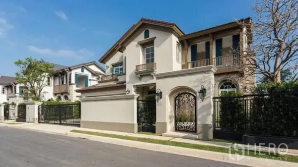 Detached House for rent in Bang Phli, Samut Prakan - Gated luxury detached house with stucco facade, balconies and wrought-iron gate.