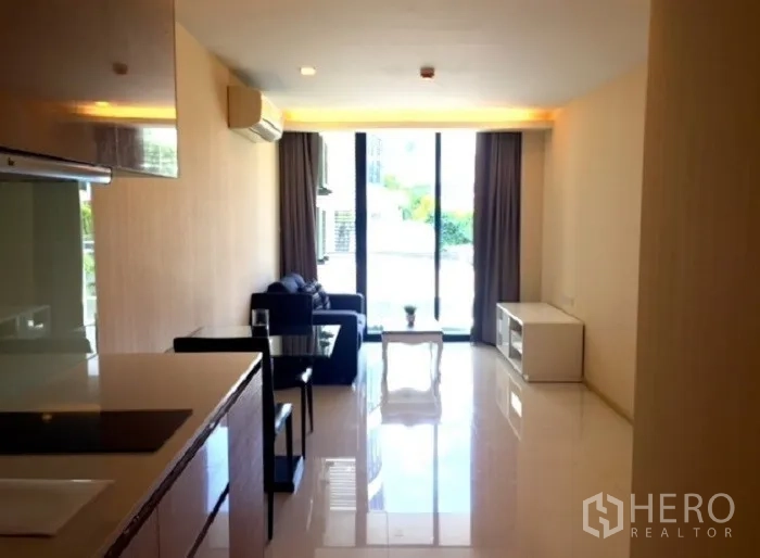 คอนโด ให้เช่าหรือขายในPathum Wan, Bangkok - ห้องนั่งเล่นสว่างด้วยแสงธรรมชาติ มีโซฟา ชุดทานอาหาร และประตูกระจกออกระเบียง ติดกับมุมครัว