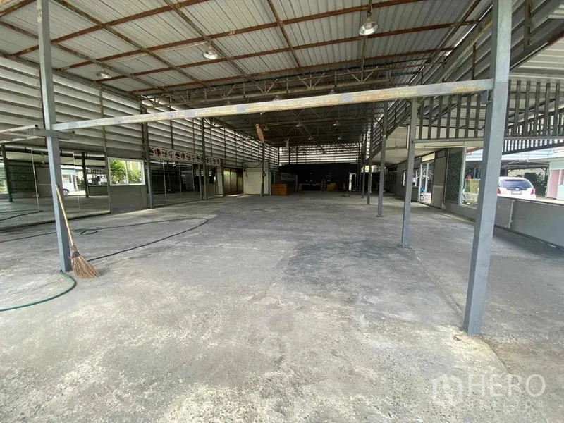 货栈 出租在Mueang Nonthaburi, Nonthaburi - 仓库内部开阔视角，金属桁架高屋顶、混凝土地面与侧窗采光。