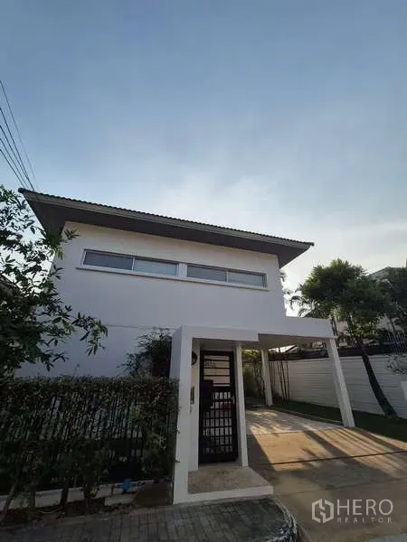 独立式住宅 出租在Bang Kruai, Nonthaburi - 两层白色独栋别墅，带车棚与入户门。