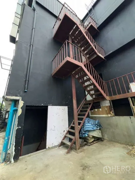 อาคารพาณิชย์ ให้เช่า - บันไดหนีไฟเหล็กภายนอกติดผนังอาคารสีดำ