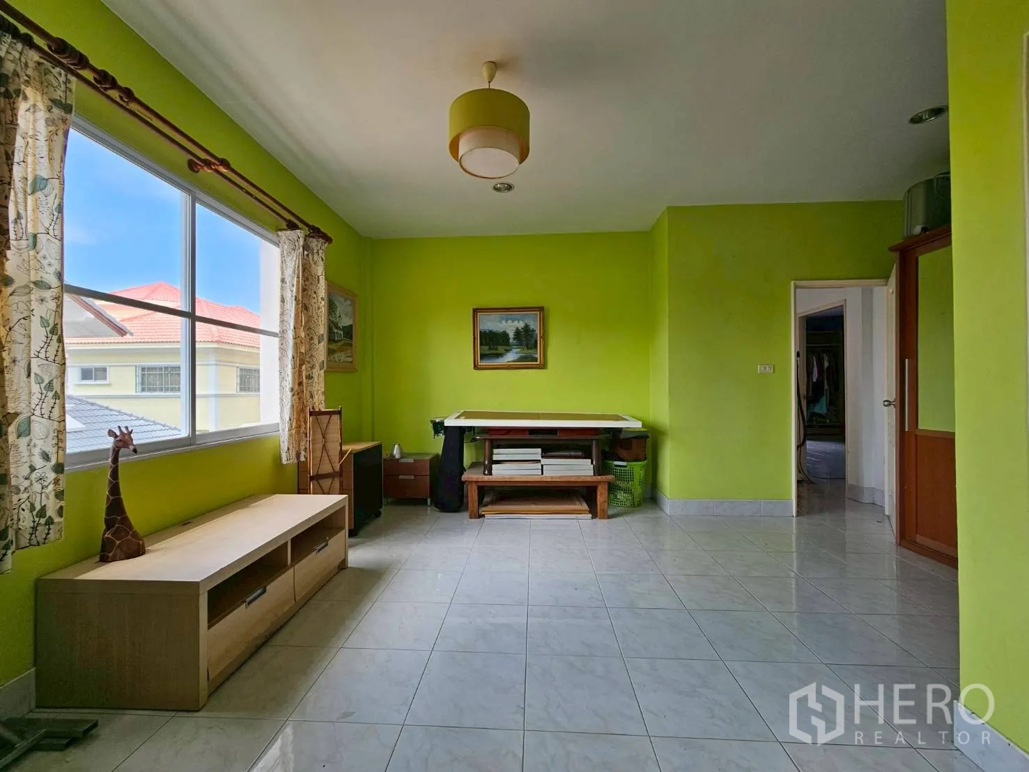 Detached House for rent or sale in Bang Lamung, Chon Buri - Bright green multipurpose room with large windows and tiled floors.