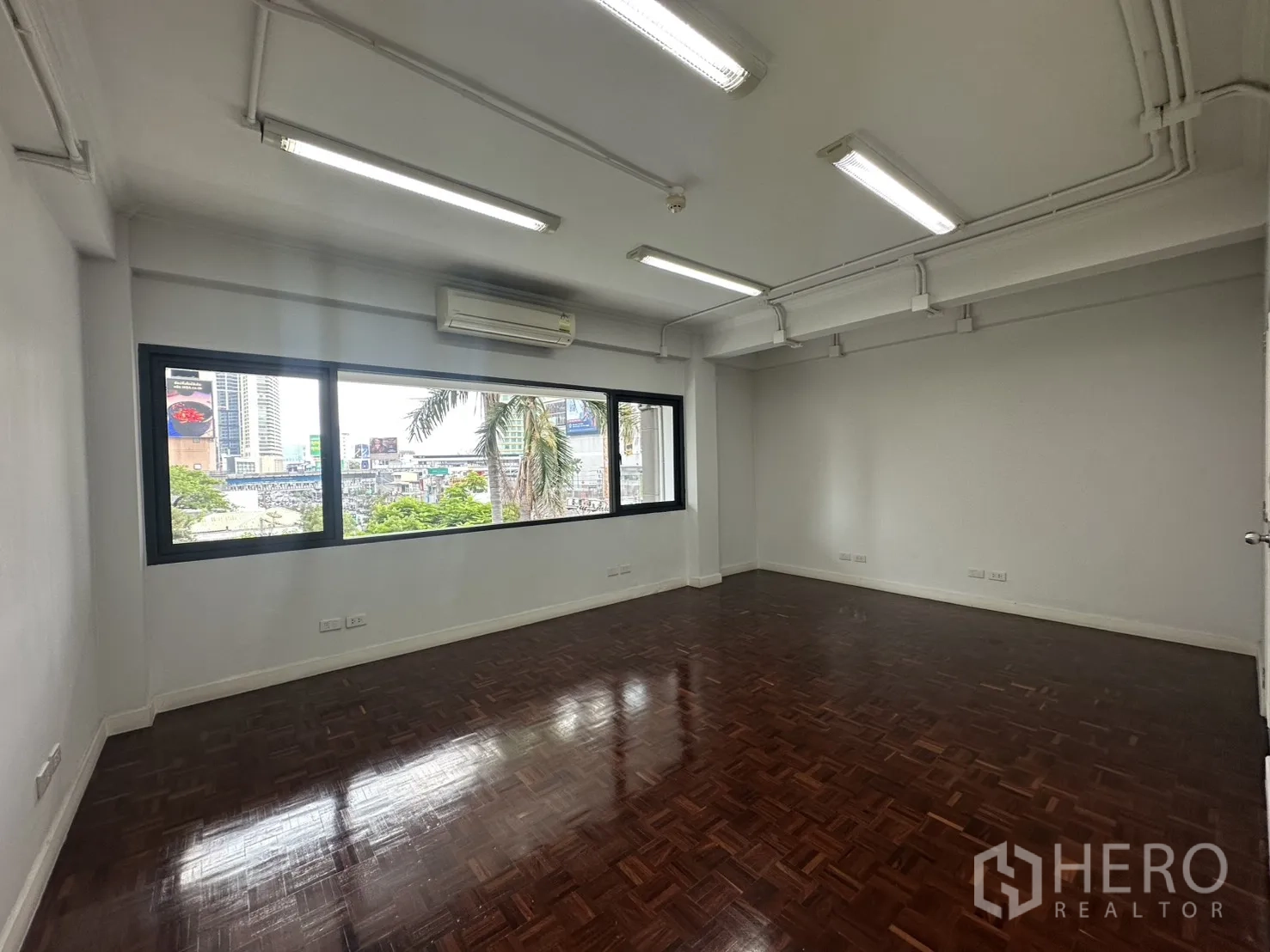 办公室 for rent in Watthana, Bangkok - 转角办公区，宽窗、空调与绿意城市景观。