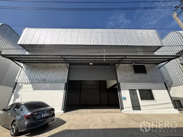 คลังสินค้า ให้เช่าในLat Krabang, Bangkok - ด้านหน้าโกดังเมทัลชีท ประตูม้วนใหญ่ พร้อมหลังคาโหลดสินค้าและที่จอดรถ