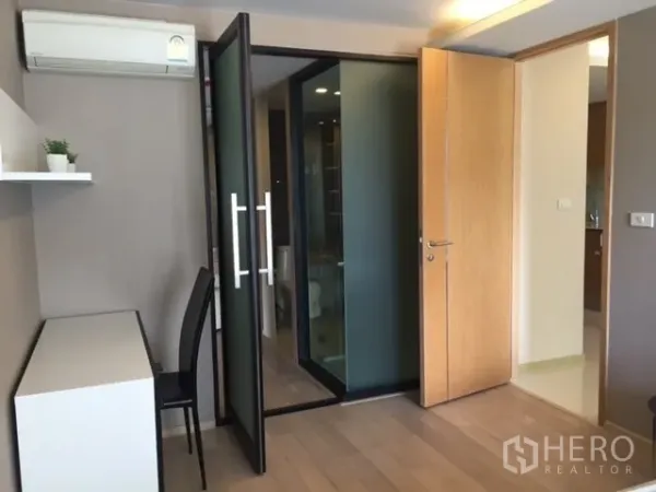 คอนโด ให้เช่าหรือขายในPathum Wan, Bangkok - มุมห้องนอนมีโต๊ะทำงาน แอร์ และประตูกระจกเชื่อมไปยังห้องน้ำ