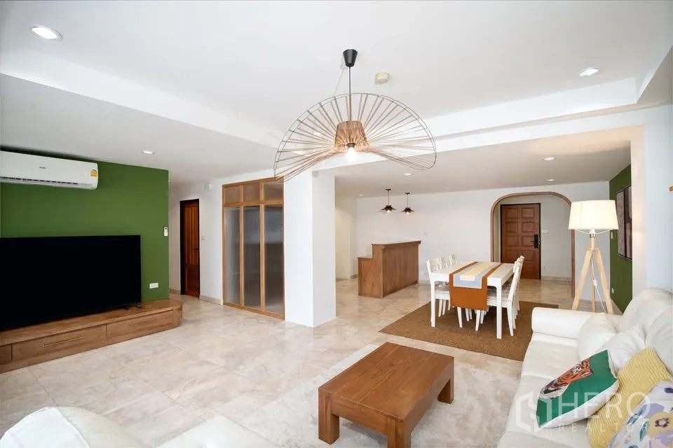 คอนโด for rent in Watthana, Bangkok - พื้นที่นั่งเล่นและรับประทานอาหารแบบเปิด พร้อมโซฟาสีขาว ทีวี และโคมไฟห้อย.