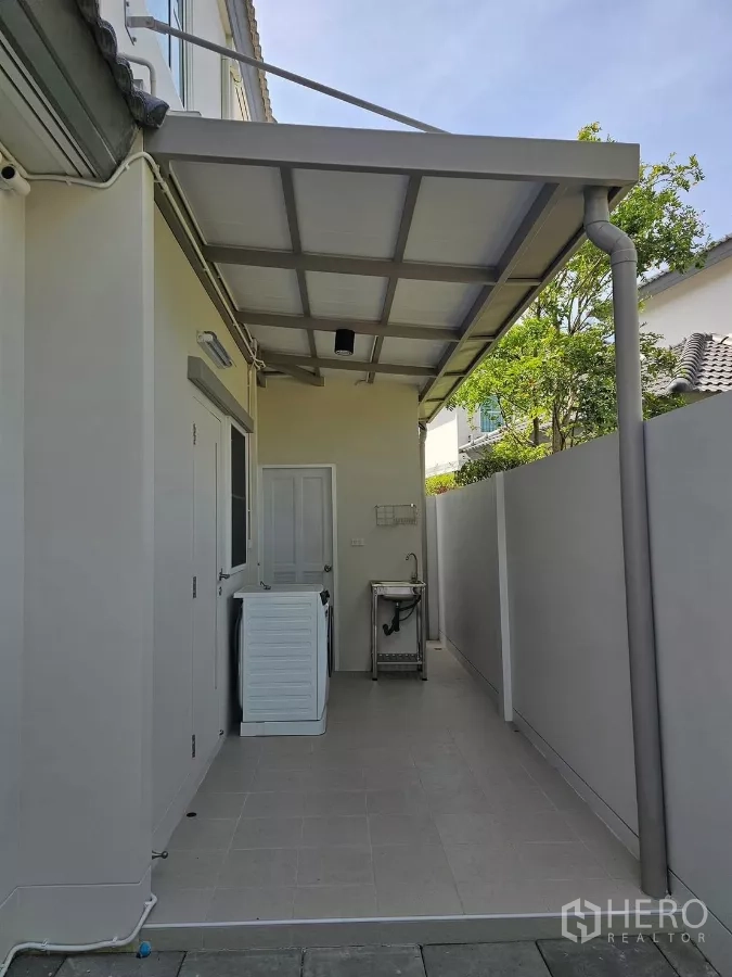 Detached House for rent in Bang Phli, Samut Prakan - Covered utility area with washing machine and sink beside service door.